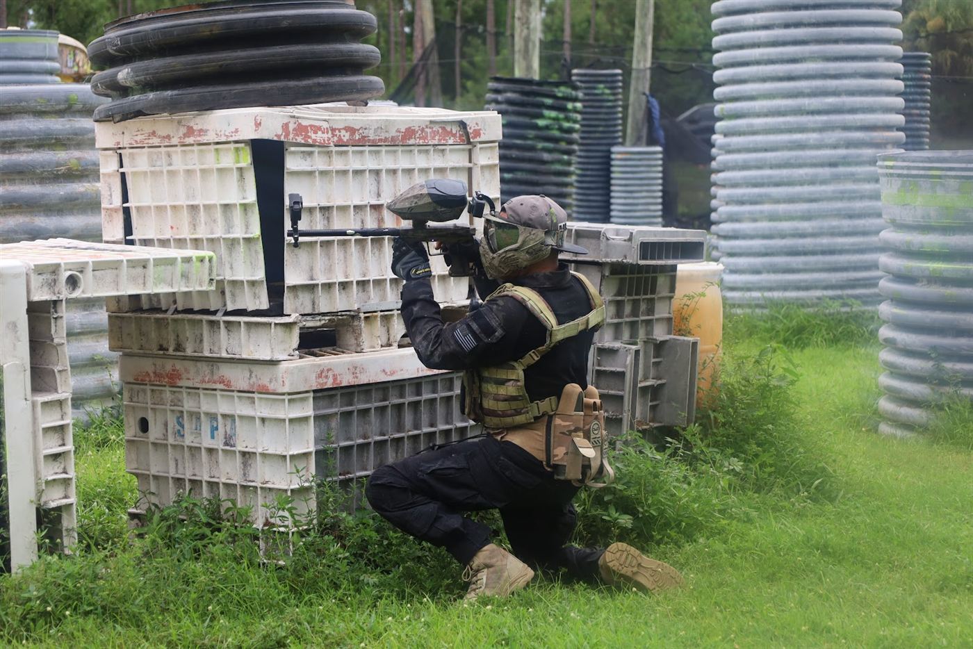 Player kneeling behind stacked crates, taking a shot