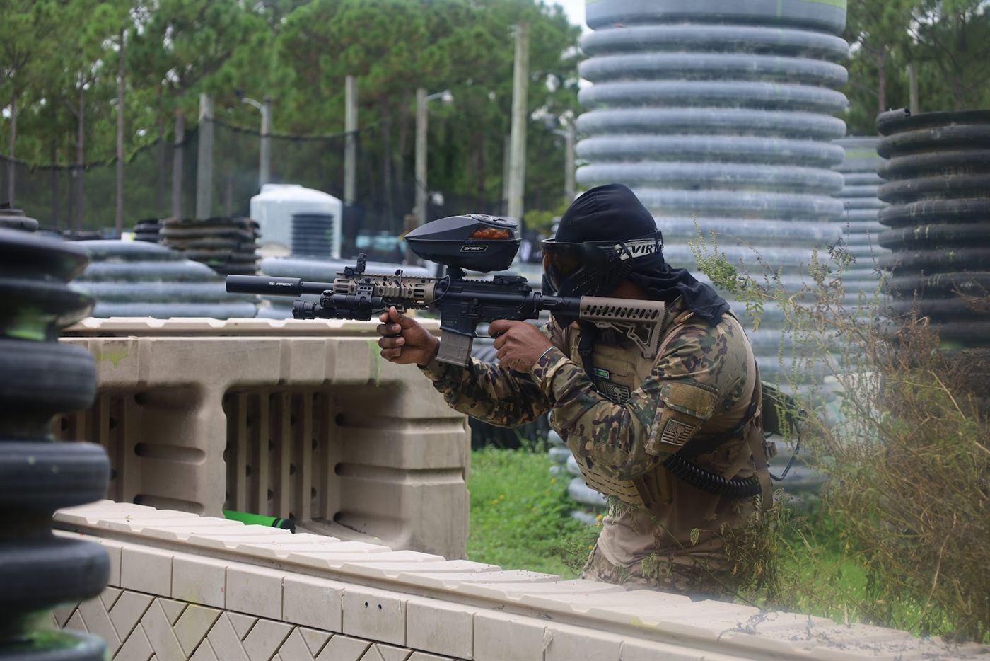 Player in camo aiming over a wall bunker